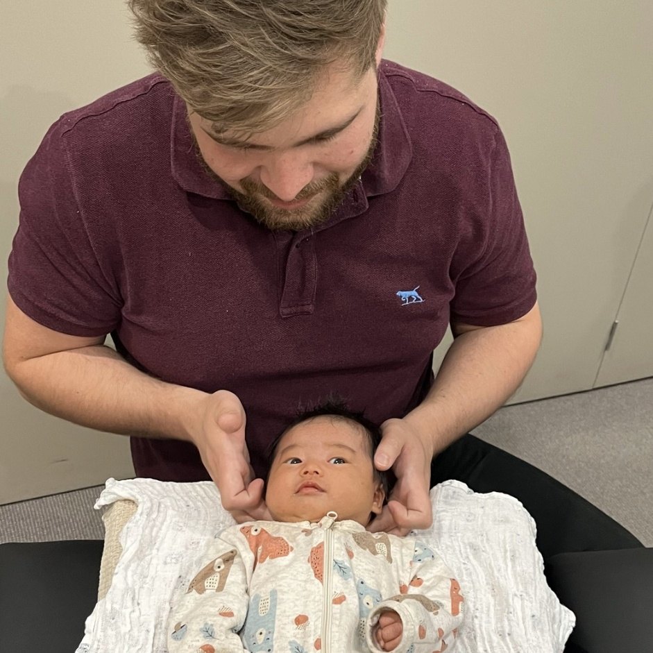 Dr Matt gently checking a newborn baby