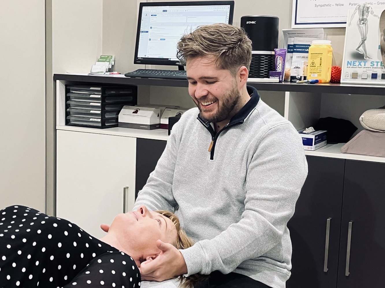 Dr Matt laughing with a patient while working on her neck
